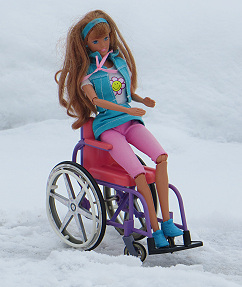 Foto von der Puppe Becky im pinkfarbenen Rollstuhl