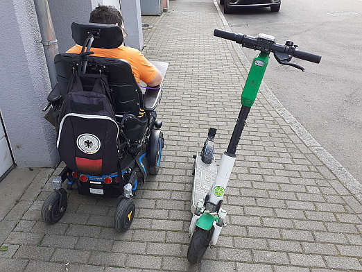 Nicht nur für Menschen im Rollstuhl ein Ärgernis: mitten auf dem Gehweg abgestellte E-Scooter